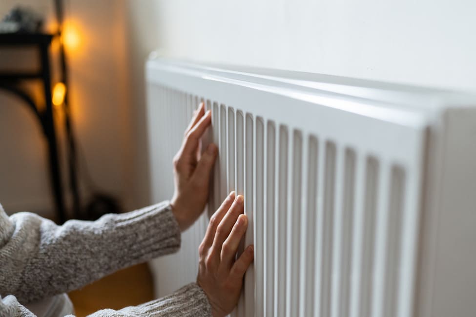 closeup-of-woman-in-sweater-puts-hands-on-room-cen-2023-01-21-00-18-03-utc.jpg