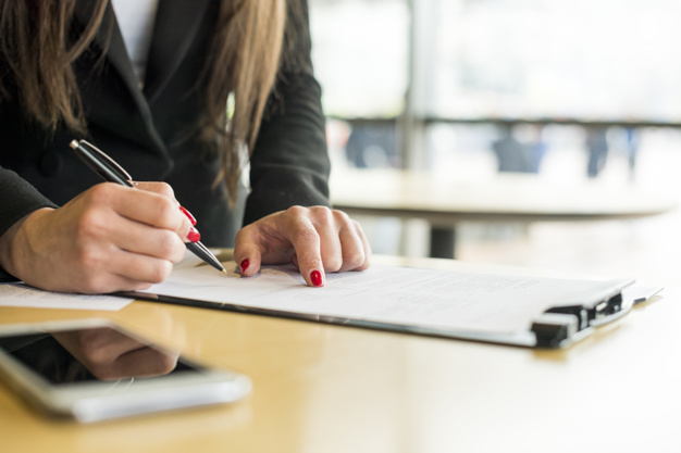 brunette-businesswoman-writing-on-a-document_23-2148142698.jpg